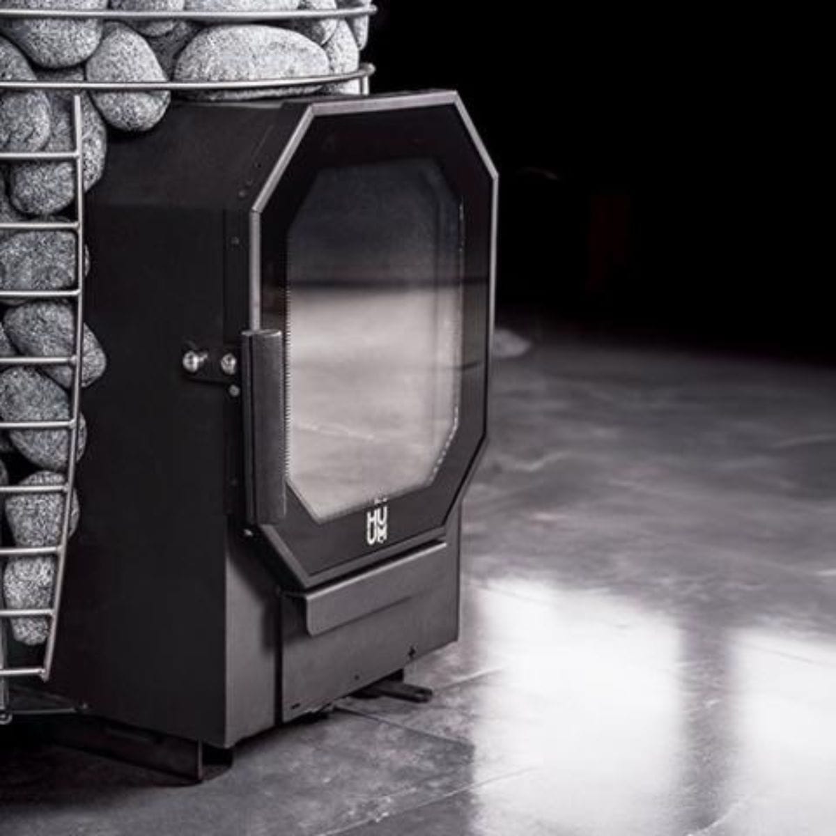 Vintage-style fireplace with a glass door in a dimly lit room.