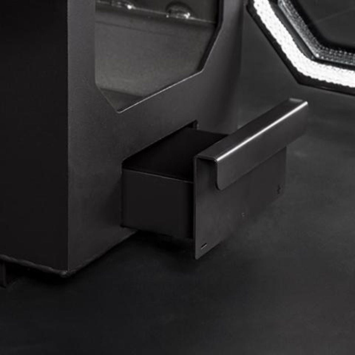 Close-up of a sauna heater with an ash compartment open on a dark background