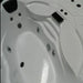 Close-up of a white Jacuzzi bathtub with water jets and control panel.
