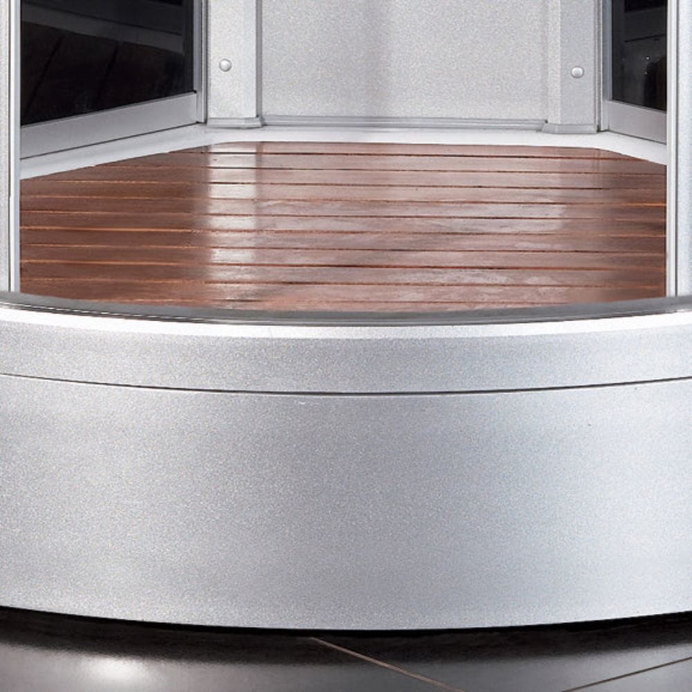 Close-up of a curved metal edge with wooden surface inside a vehicle.