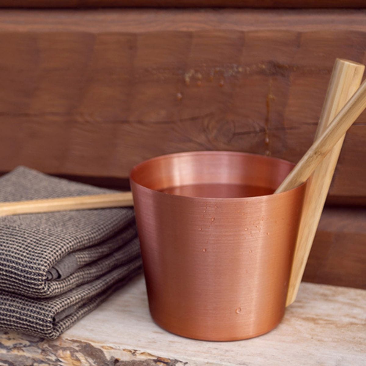 Copper cup with wooden spoon on a wooden surface