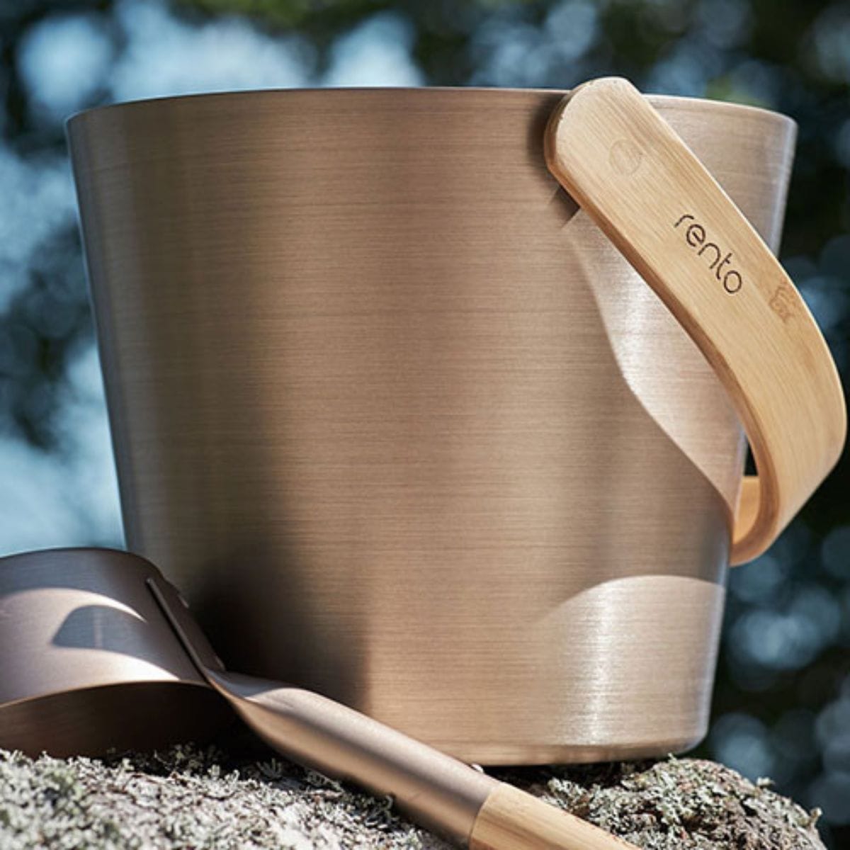 Brown ceramic bucket with wooden handle and ladle on a natural background