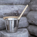 Metal bucket with wooden handle on a wooden surface