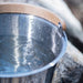 Metal bucket with wooden handle on a natural background