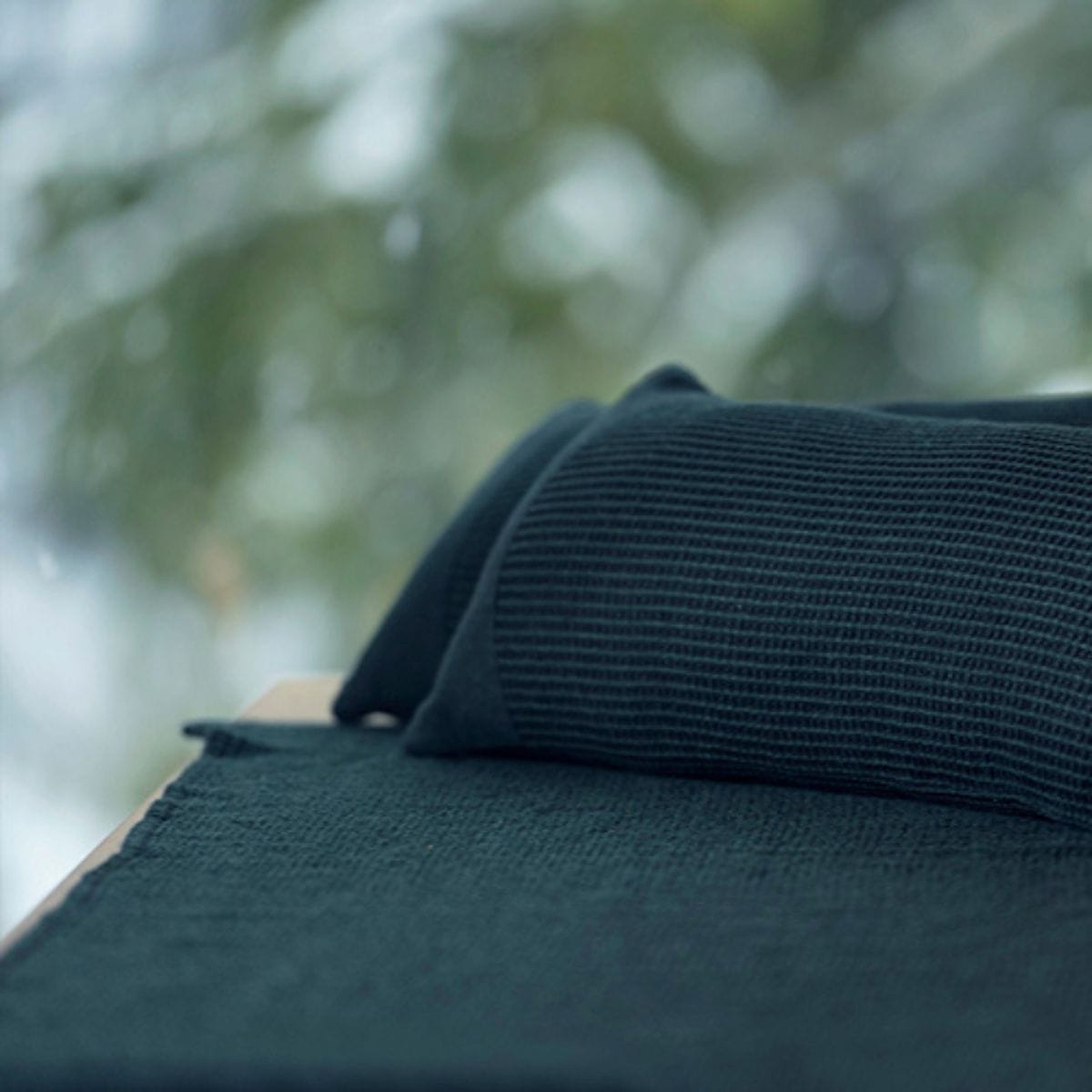 Dark green fabric with a blurred natural background