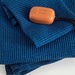 Blue textured blanket with a brown rectangular object on top