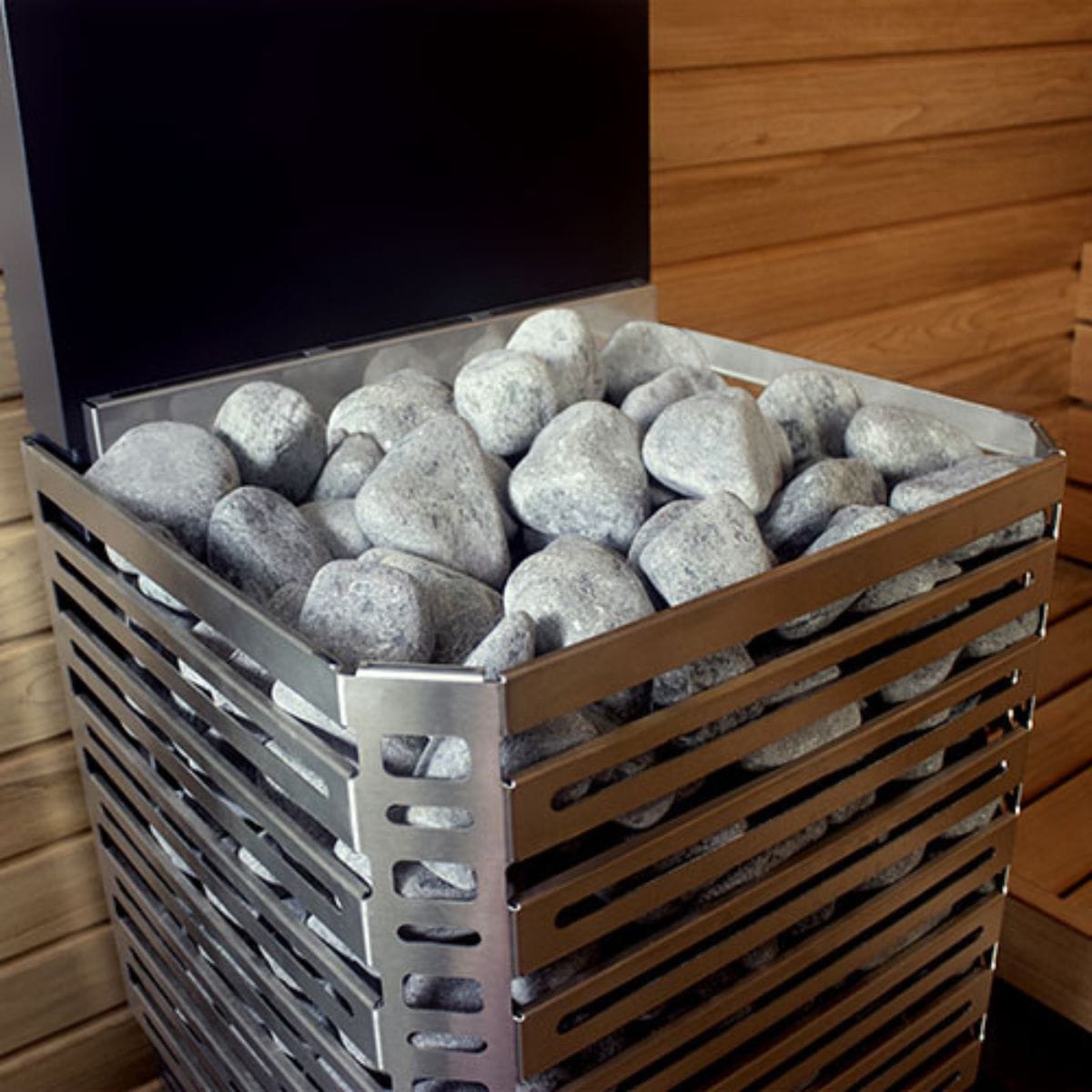 Metal basket filled with stones against a wooden wall