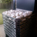 Metallic planter box with decorative stones on a patio